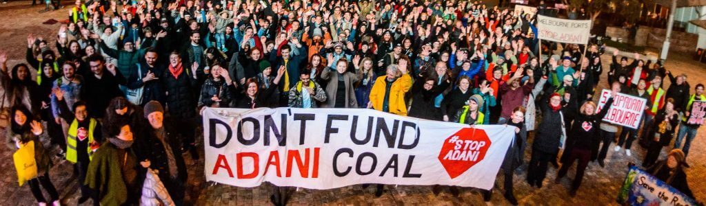 Crowd with 'don't fund Adani coal' banner