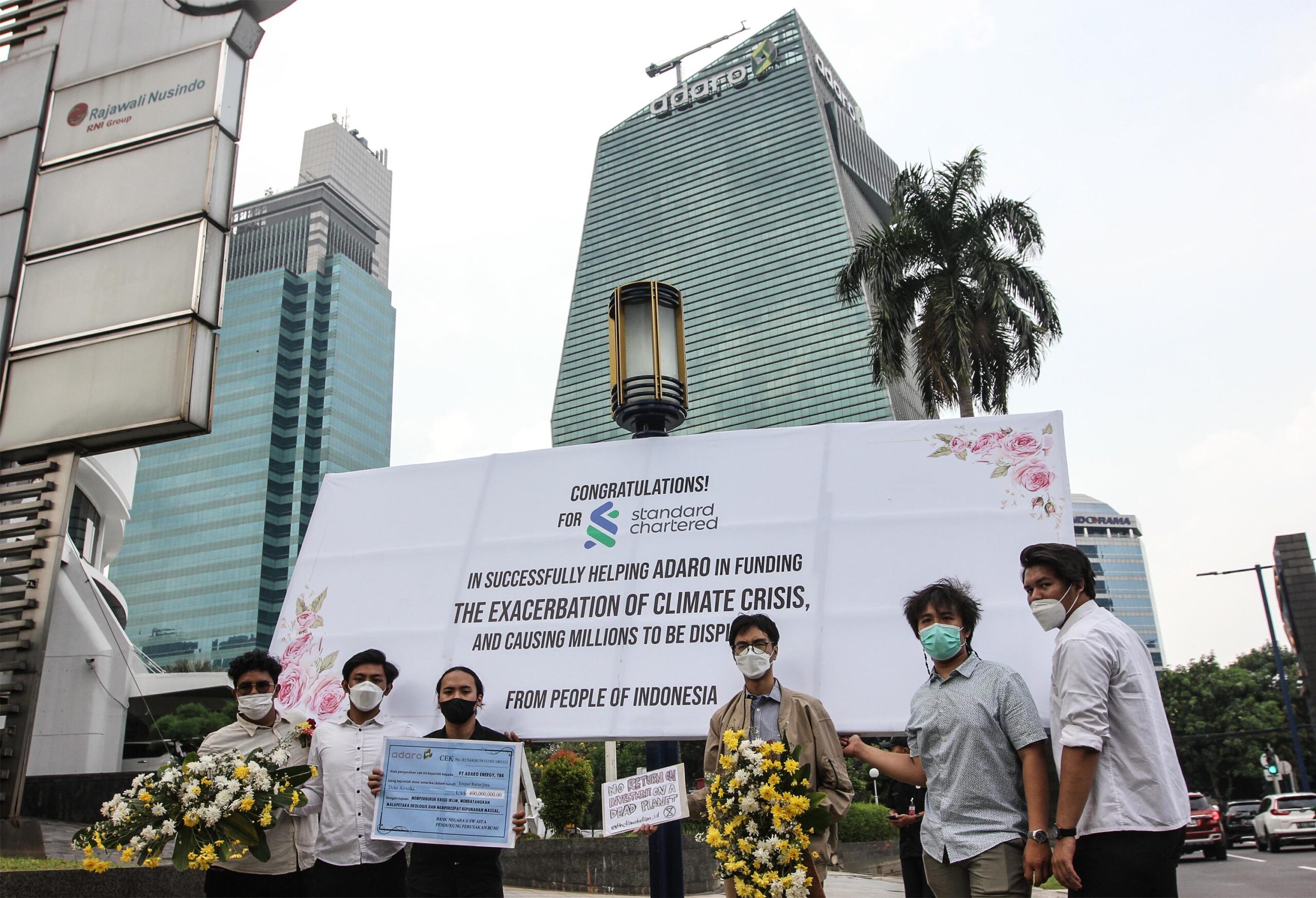 Action in front of the Adaro Energy office, calling out Standard Chartered