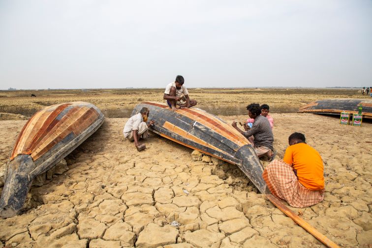 Local community members repairing their boats on the empty swathes of land set aside for Japan-backed LNG to power project proposed to be built in Matarbari, Bangladesh. Photo credit: Market Forces