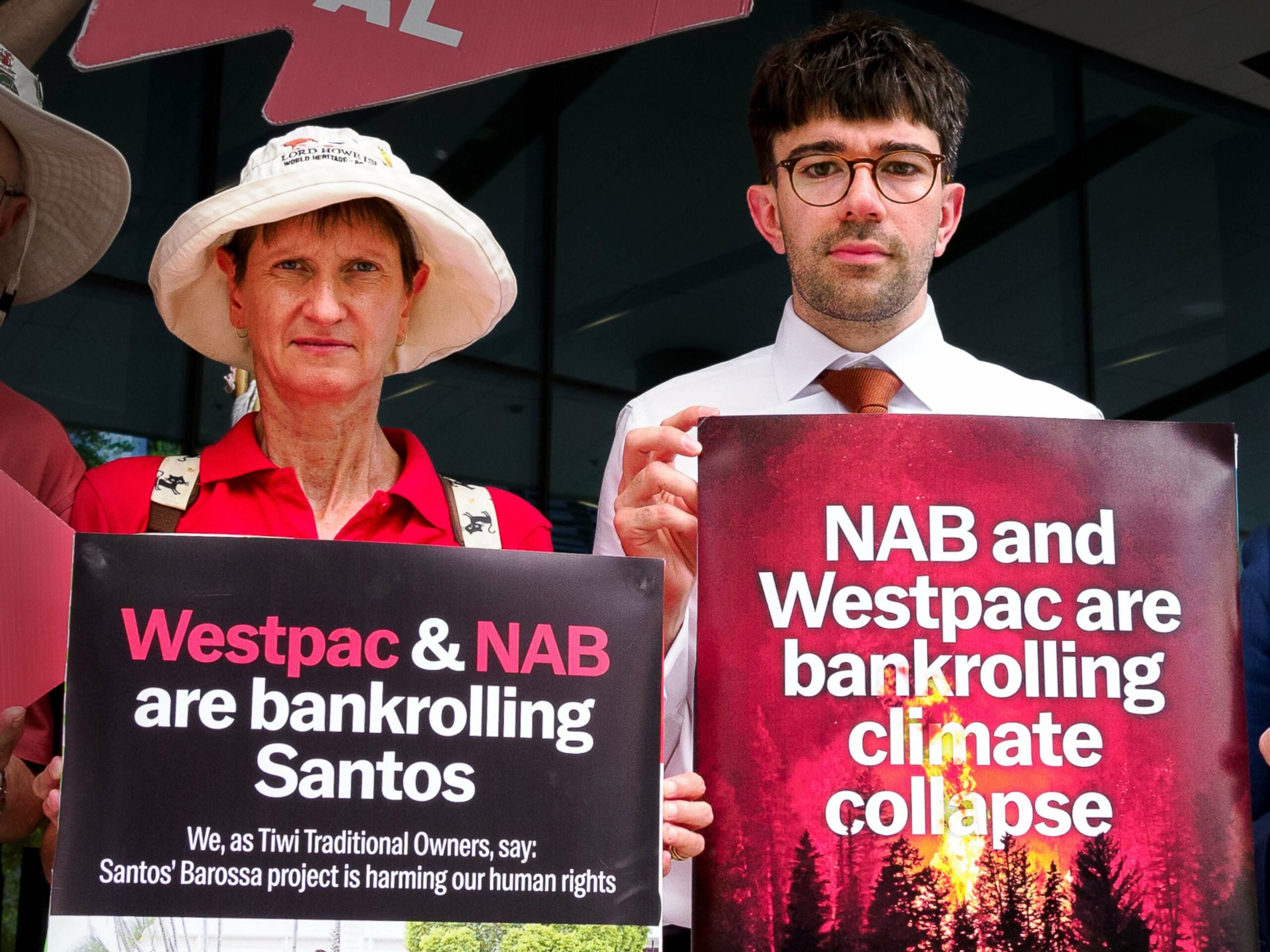 Supporters hold signs at the Westpac and Nab AGMs, asking the banks to stop financing Santos and other climate wreckers